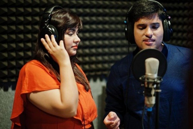 A boy plays a piano with his friend and they have fun, music class